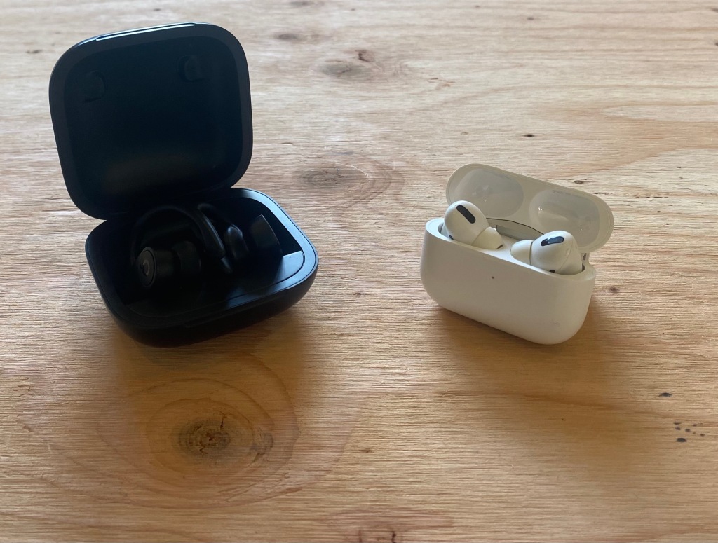 PowerBeats Pro case next to Apple Airpods Pro case on a desk