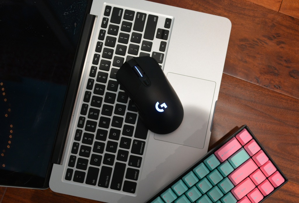 Logitech G703 Hero with a laptop and keyboard.
